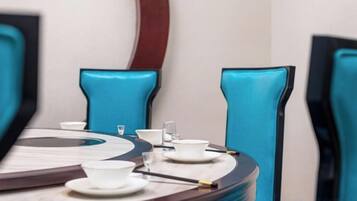 A conference table with chairs, a round table, and a mirror.