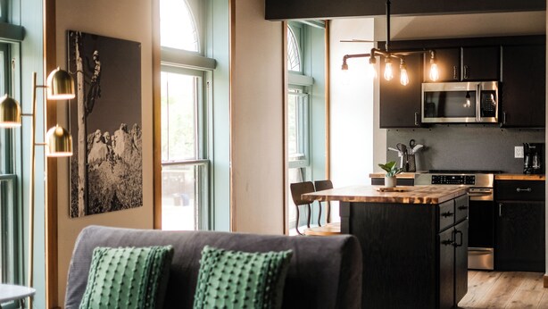 A modern kitchen with dark cabinetry, a built-in microwave, and a central island.