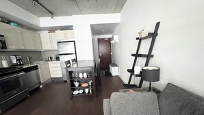 A modern kitchen with a dining area, a sofa, and a ladder against the wall. - Downtown Toronto  (Toronto)