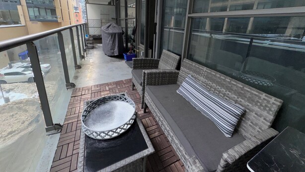 A balcony with a seating area, a covered table, and a view of the cityscape. - Downtown Toronto  (Toronto)