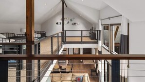 Um interior com vários níveis, incluindo uma escada, área de jantar e sala de estar.