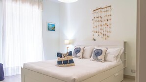 A neatly arranged bedroom with a bed, bedside tables, a lamp, and a wall decoration.
