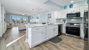 Una cocina moderna con armarios blancos, electrodomésticos de acero inoxidable y una isla grande.
