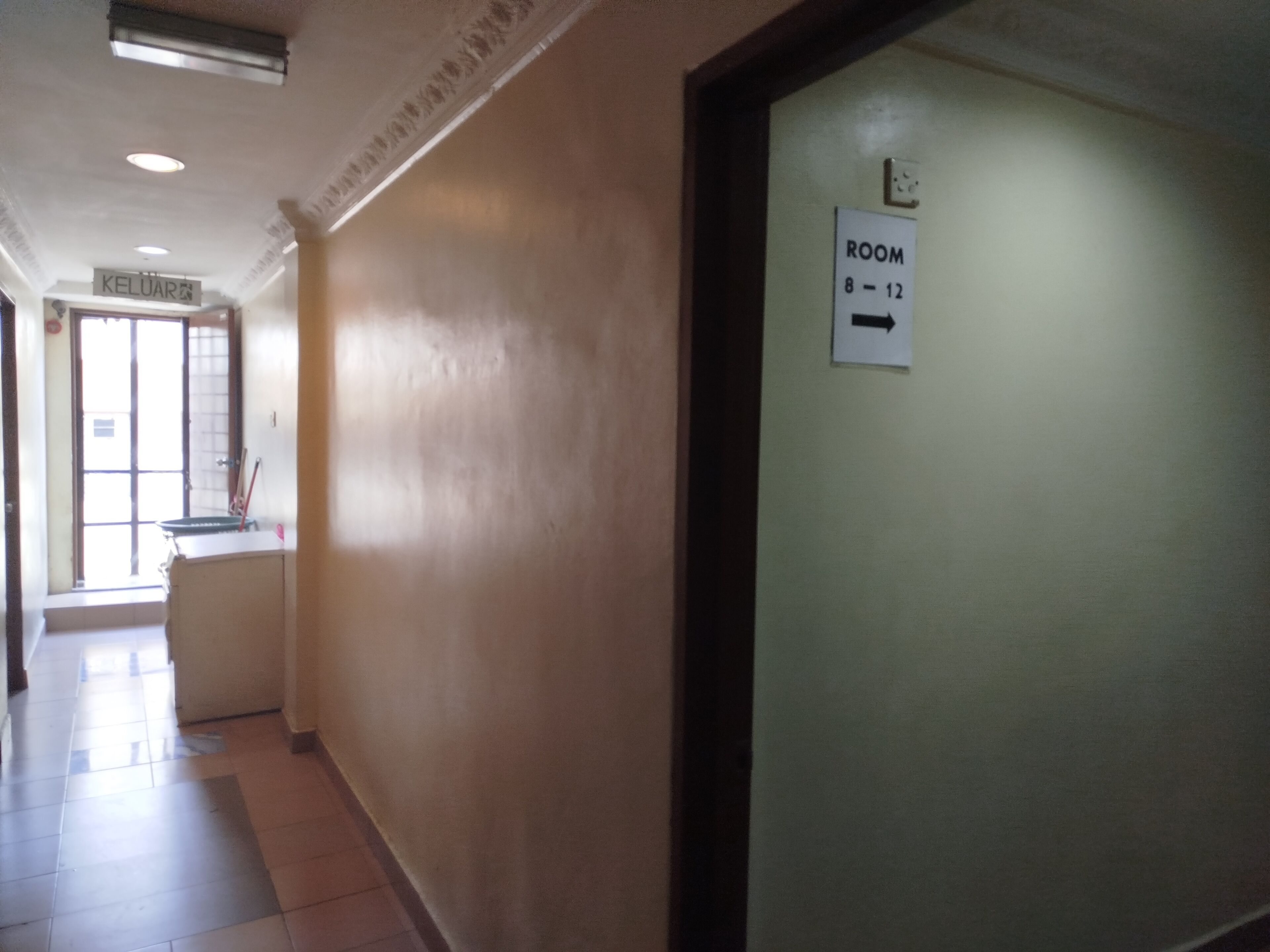 A hallway with a sign indicating ROOM 8-12.