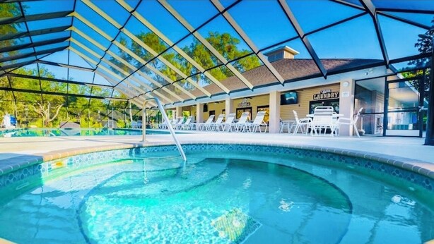 A swimming pool with a covered area, lounge chairs, and a laundry facility. - Get 10% off on weekly stay or 15% on monthly stay. Fully equipped cabin. CR. Fl (Crystal River)