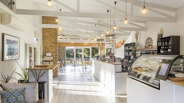 A modern cafe with a central counter, seating area, and a view of the outdoors. - Island Haven Villa Ramada Resort (Cowes)