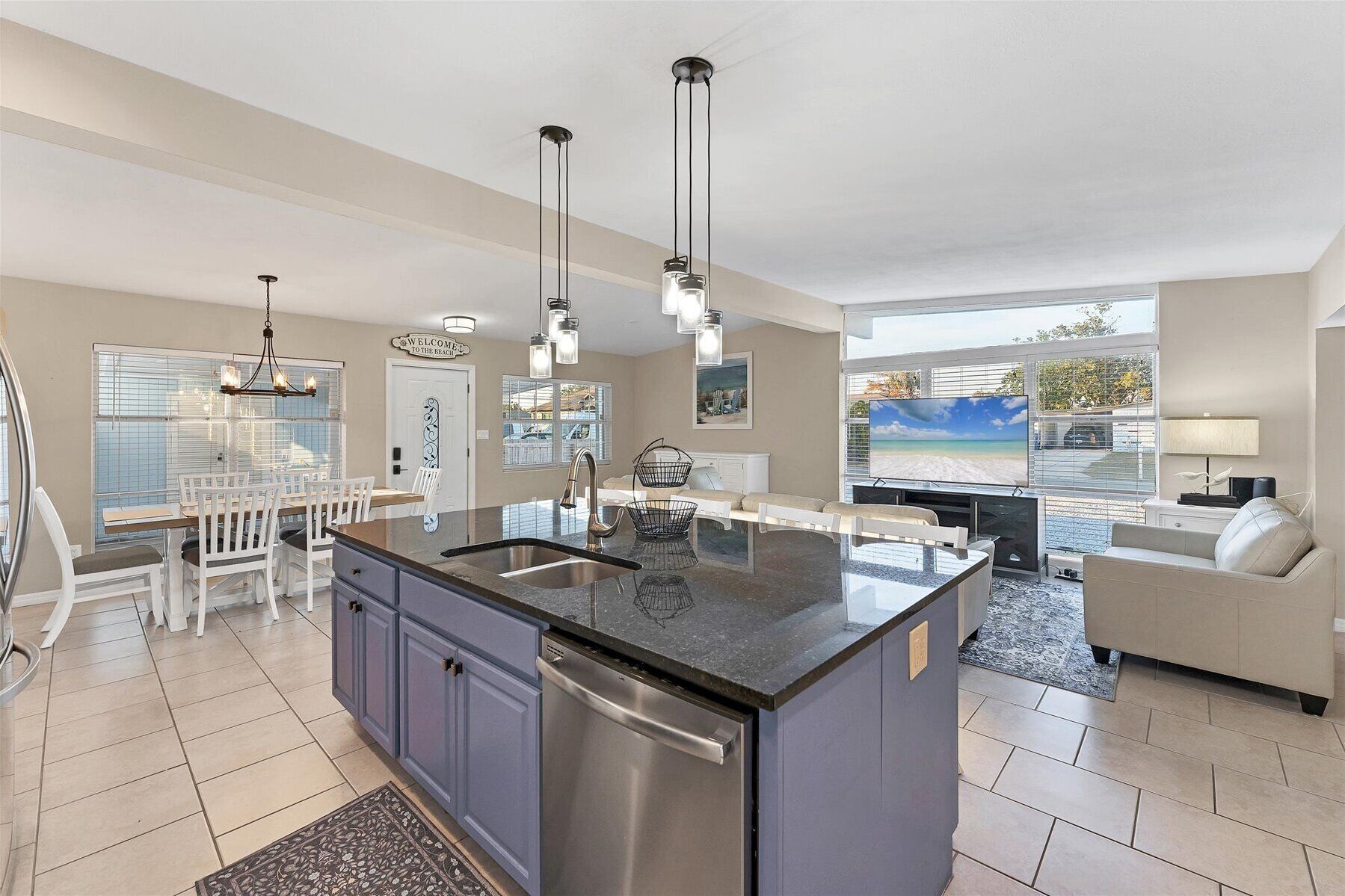 A modern kitchen with a central island, stainless steel appliances, and pendant lighting.