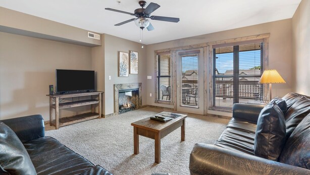 A living room with a fireplace, a ceiling fan, a television, and a sofa. - 1 Bedroom, sleeps  up to 6, Steps to Table Rock Lake! Ticket Deals! (Branson)