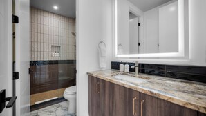 A modern bathroom with a marble countertop, a large mirror, and a shower area. - Montclair Zion - a Stunning Luxury Villa, 2 Bed, 1 Bath Retreat with Patio (Springdale)