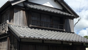 A traditional wooden house with a tiled roof, a wooden porch, and a small garden area. - Jisaburo Ozawa Residence (Takanabe)