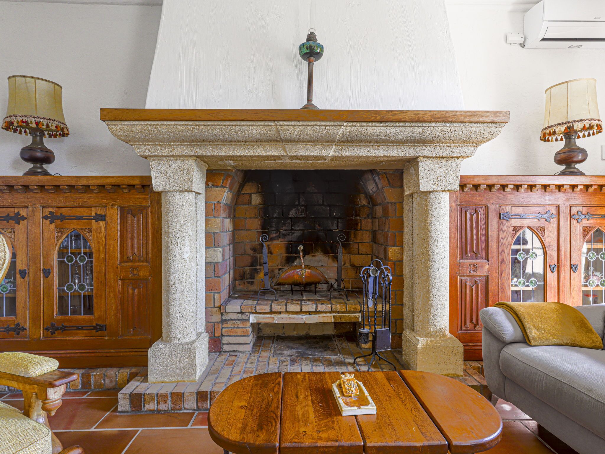 Une pièce avec une cheminée en pierre, des meubles en bois et un canapé.