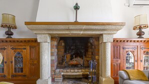 A room with a stone fireplace, wooden furniture, and a sofa. - Le Mas de Gattières by Interhome (Vence)