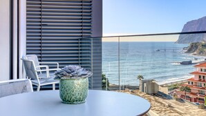 A balcony with a view of the ocean, a potted plant, and a table with chairs. - Funchal Acqua Blue 8E, a Home in Madeira (Funchal)