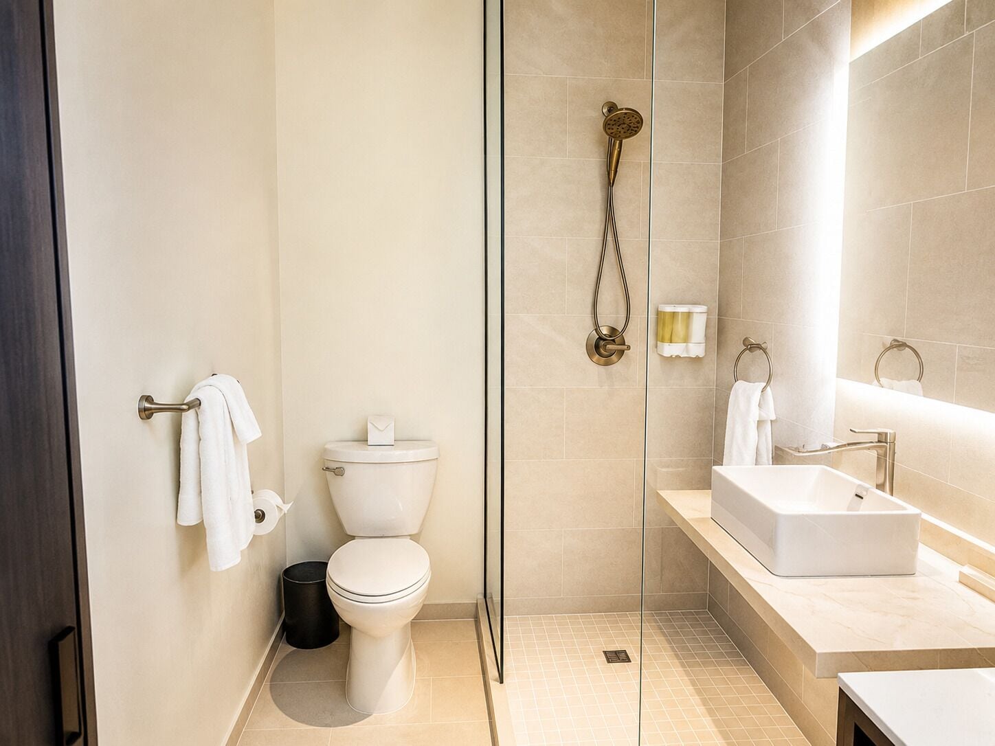 A modern bathroom with a toilet, shower, and sink.