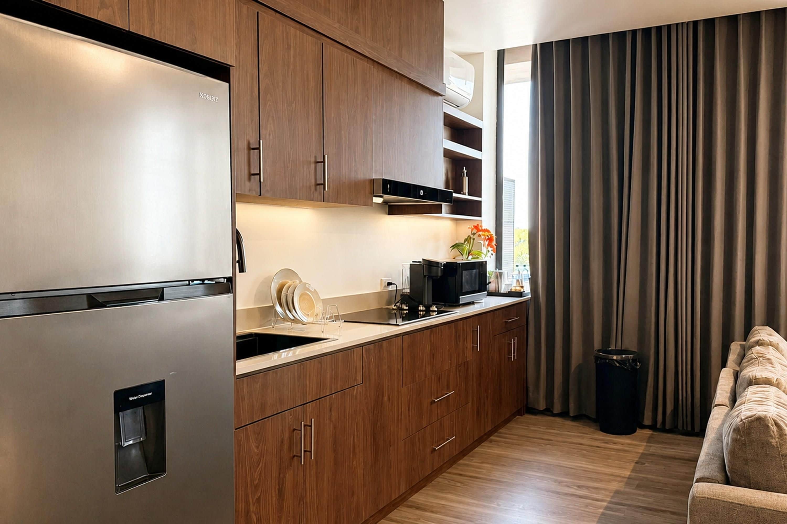 A modern kitchen with wooden cabinets, stainless steel appliances, and a built-in dishwasher.