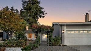 A residential driveway leading to a house with a garage, surrounded by a garden with various plants and flowers. - Japandi Garden Home/Jacuzzi/Game Room/BBQ/Fire pit (San Jose)