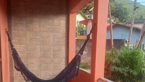 A hammock hanging between two red pillars on a tiled floor, with a wooden bench to the right. - Angra dos Reis - Beachfront House - Praia de Fora - East End (Unknown)