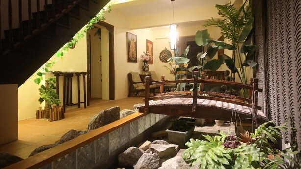 A staircase with a wooden railing, a small wooden bridge, and various potted plants. - Penang Story Linn House (George Town)