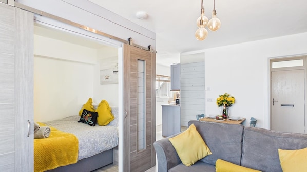 Une chambre moderne comprenant un lit, un canapé, une table à manger et un coin cuisine.