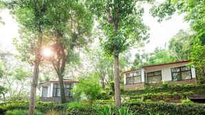 A house surrounded by lush greenery and trees. - amã Stays & Trails Writer's Hill Nahan, Sirmaur Himachal (Nahan)