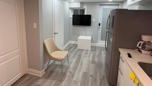 A modern kitchen with a built-in refrigerator, a microwave, and a coffee maker. - Brand new 1 bedroom Fully Furnished apartment (Brampton)