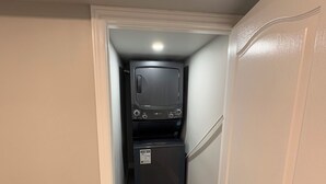 A narrow hallway with a small kitchenette area featuring a microwave and a refrigerator. - Brand new 1 bedroom Fully Furnished apartment (Brampton)
