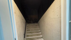 A narrow stairway with a concrete floor and walls painted in light colors. - Brand new 1 bedroom Fully Furnished apartment (Brampton)