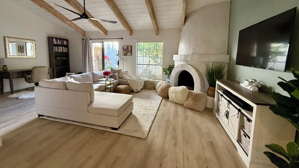 A spacious living room with a fireplace, a large TV, and a cozy seating area. - Central Scottsdale- Spanish style patio home -2bd 2ba 2 car garage -on bike path (Scottsdale)