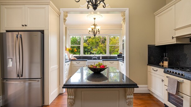 A kitchen with a central island, stainless steel appliances, and a view of greenery outside. - Secret Garden - historic charm meets Bowral vibe (Bowral)