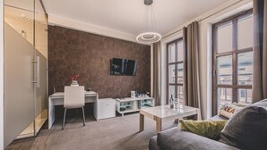 A modern hotel room with a sofa, a dining table, a small kitchen area, a TV mounted on the wall, and large windows. - Dream 23A Studio z Przeszklon Azienk Centrum (Bydgoszcz)