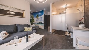 A modern living room with a sofa, coffee table, and a painting of a beach scene. - Dream 23A Studio z Przeszklon Azienk Centrum (Bydgoszcz)