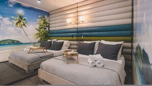 A bedroom with two beds, a mural of a beach scene, and a nightstand with a tray of towels. - Dream 23A Studio z Przeszklon Azienk Centrum (Bydgoszcz)
