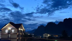 A hotel with a traditional architectural style, featuring a prominent signboard and a balcony. - Vang Vieng Family Boutique Hotel (Vang Vieng)
