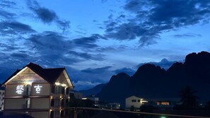 A hotel with a traditional architectural style, featuring a prominent signboard and a balcony. - Vang Vieng Family Boutique Hotel (Vang Vieng)