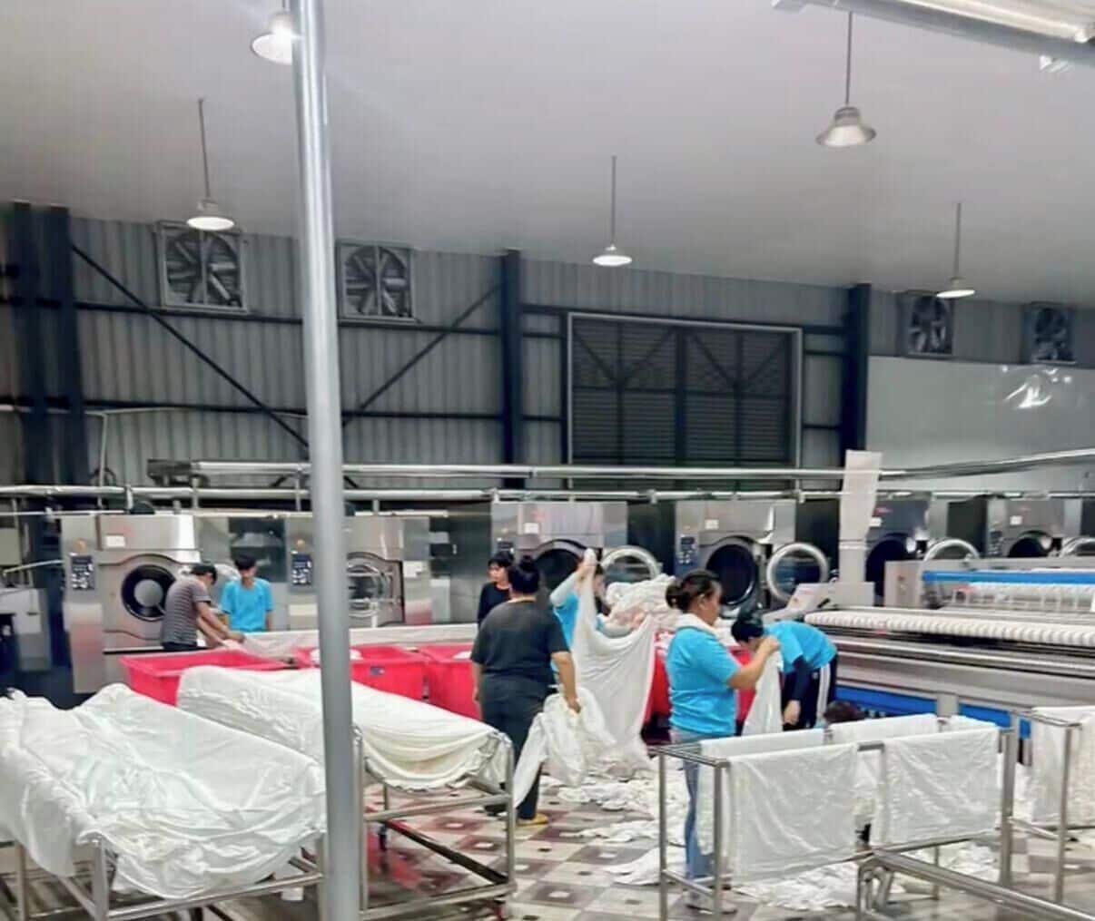 A large industrial laundry facility with multiple washing machines and drying racks.