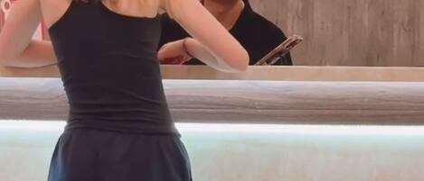 Una mujer está de pie junto al mostrador de recepción en el vestíbulo de un hotel, con un cartel que dice "ABS" y "HOTEL".