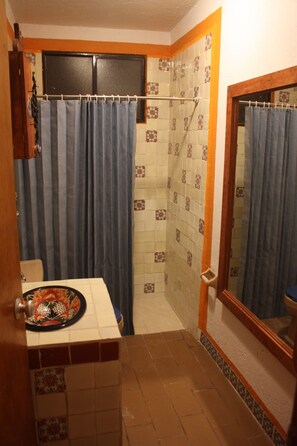 Een douche, handdoeken, zeep, toiletpapier