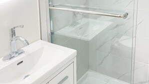 A modern bathroom with a glass shower enclosure, a round mirror, and a white sink. - Beautiful place with Kitchen, Washing Machine, Internet near UBC, beach and DT (Vancouver)