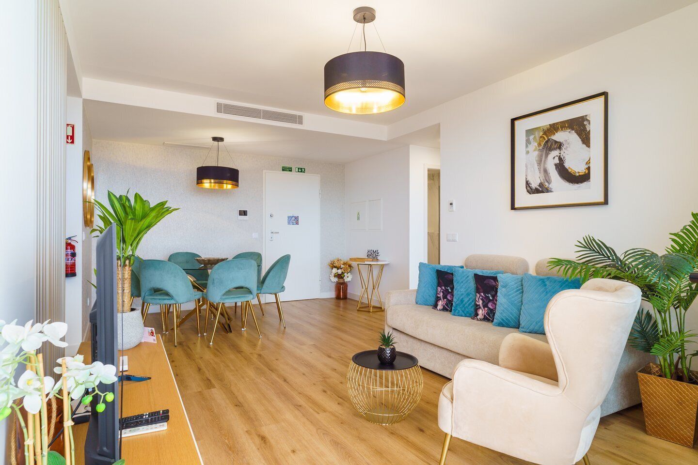 A modern living room with a sofa, chairs, a coffee table, and a dining area with chairs and a table.