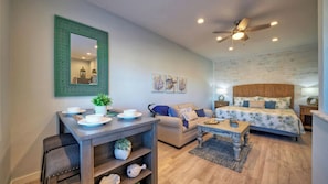 A compact living space with a dining area, a sofa, a bed, and a ceiling fan. - 2 Units Beach Boardwalk, Pool, Pickleball + Tennis Island Retreat Complex (Port Aransas)