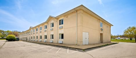 A long, beige building with multiple windows and a flat roof, likely a hotel or motel.
