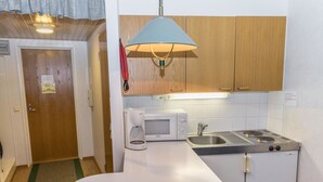 A compact kitchen with a microwave, stove, and sink.