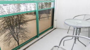 Un balcon donnant sur des arbres et un paysage enneigé.