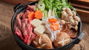 Un bol contenant un assortiment d’aliments, notamment de la viande, du tofu, des champignons et des légumes.