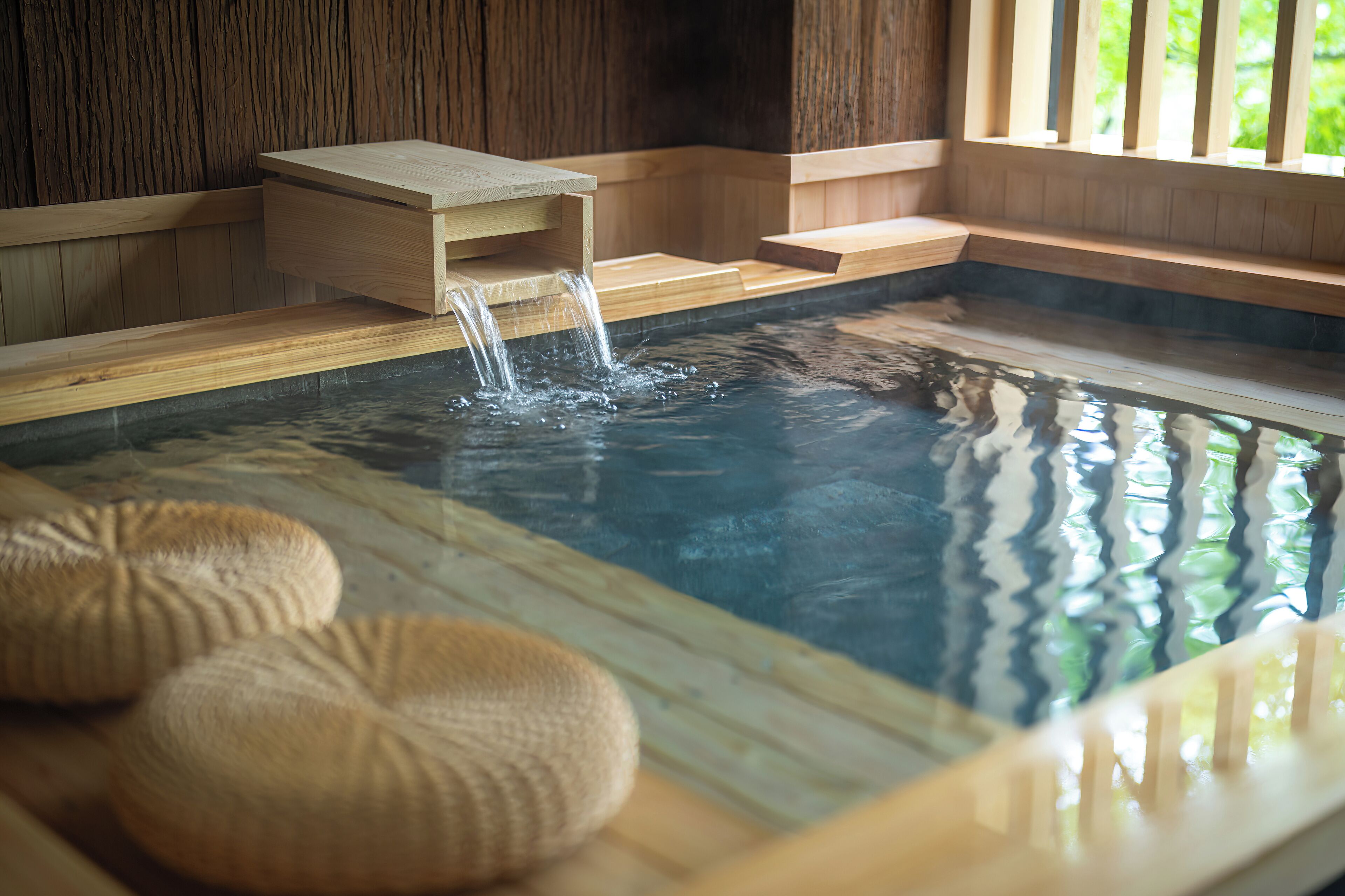 A hot spring bath with wooden benches and a wooden platform.