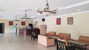 Un'ampia hall con reception, diverse zone relax e lampadari decorativi.