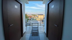 A corridor leading to a balcony with a clear view of the surrounding buildings. - Ranls Dream Syari'Ah Banda Aceh (Banda Aceh)