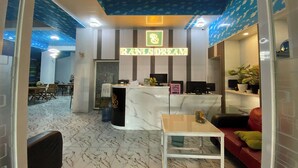 A reception area with a marble counter, a reception desk, and a seating area with a red sofa and a small table. - Ranls Dream Syari'Ah Banda Aceh (Banda Aceh)