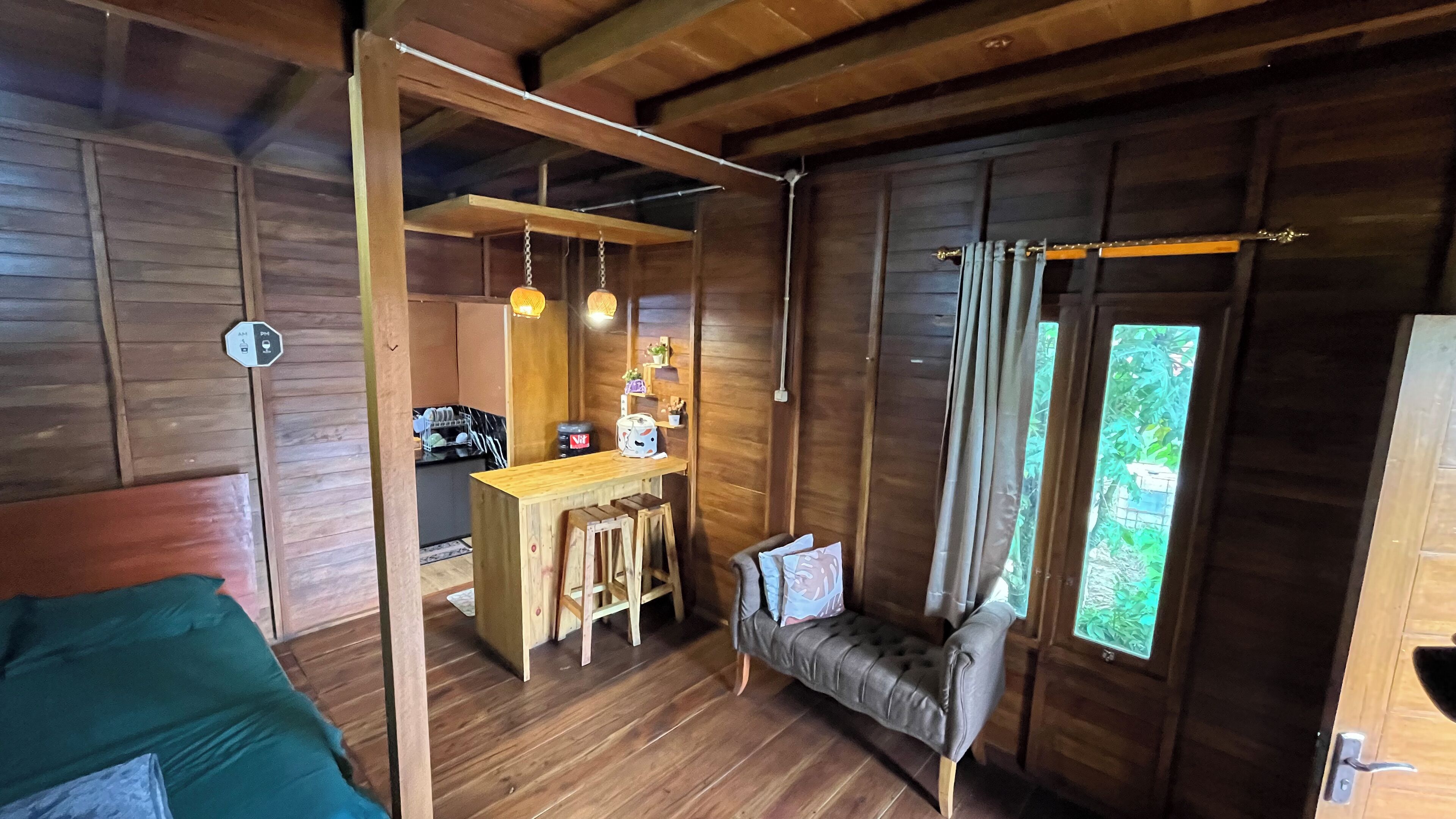 L’intérieur d’un chalet accueillant, avec un coin repas en bois, un canapé et un lit.