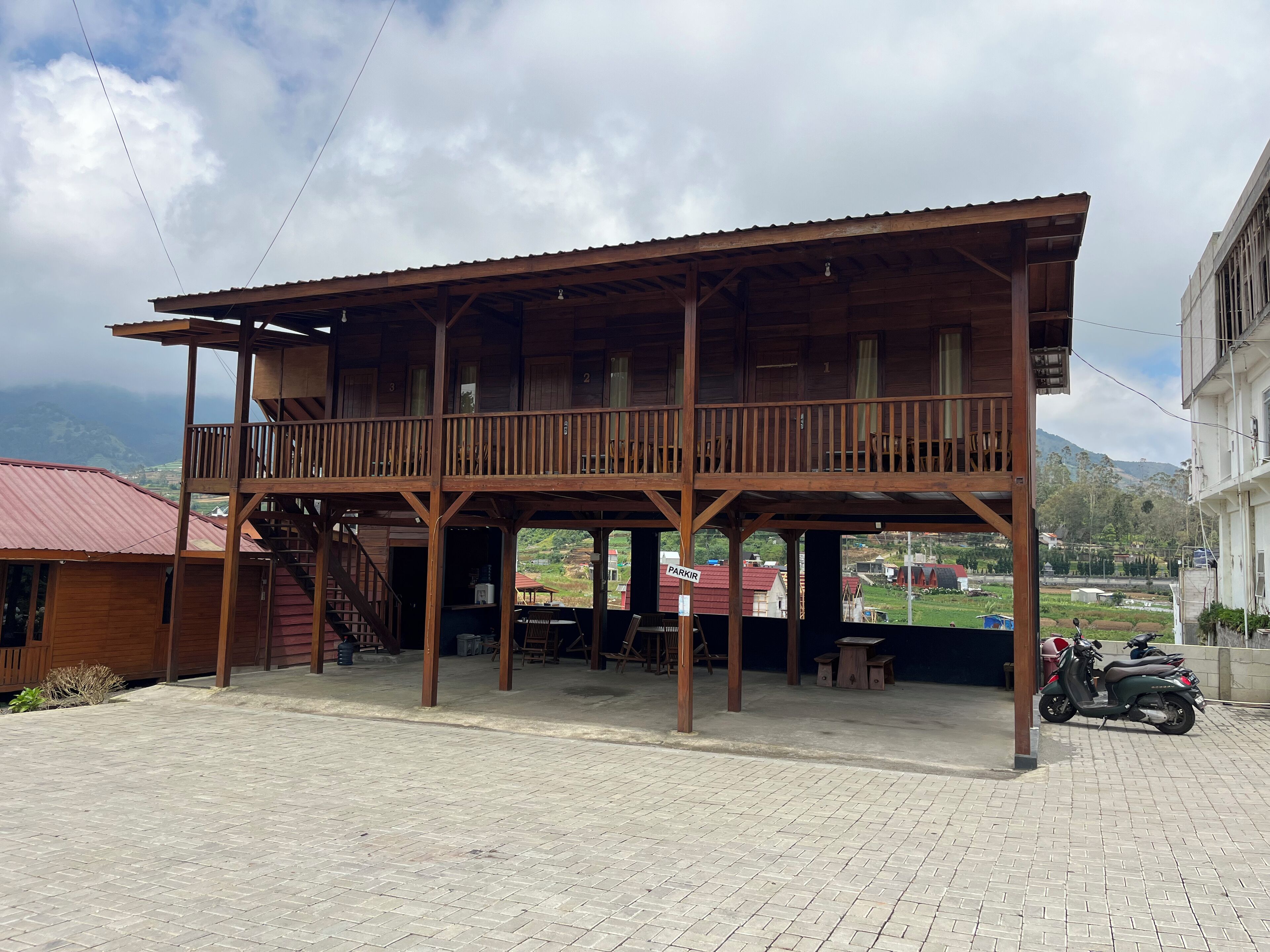 A wooden building with a balcony and a sign indicating a parking area.